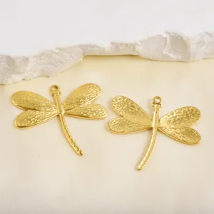 Primo piano dettagliato ciondoli libellula dorati per creazione gioielli fai da te e accessori.