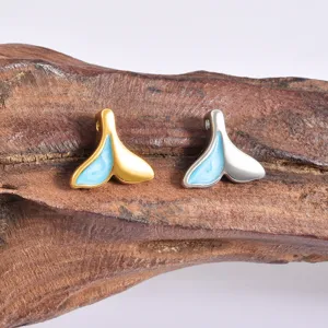 Detailed shot of cute whale tail pendants with blue enamel, ideal for DIY jewelry making.