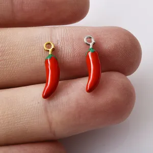 Close-up detail van kleine rode chili metalen bedels, perfect voor DIY sieraden maken accessoires.