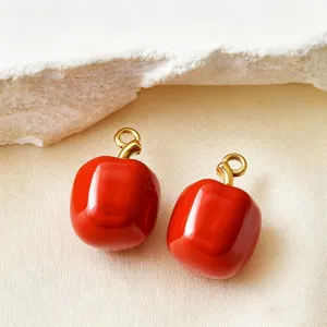 Close-up detail van glanzende rode emaille RVS DIY bedelhangers voor handgemaakte sieraden.