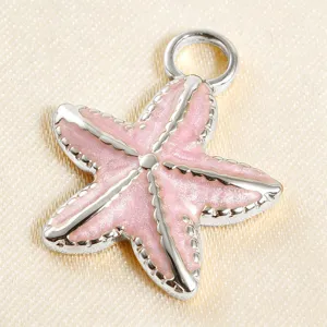 Close-up of pink glitter enamel starfish charm, delicate metal pendant detail for DIY jewelry.