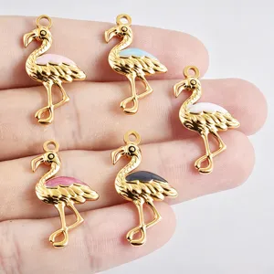 Close up of gold plated flamingo enamel charms, colorful details for DIY jewelry making.
