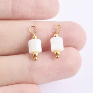 Close up of DIY handmade pearl shell jewelry pendant charm with gold metal beads for necklace.