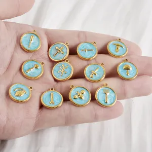 Primer plano de pequeños dijes redondos de esmalte azul de acero inoxidable con símbolos.