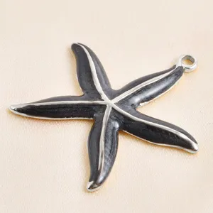 Gros plan détaillé du pendentif charme étoile de mer en émail noir pour bijoux DIY.