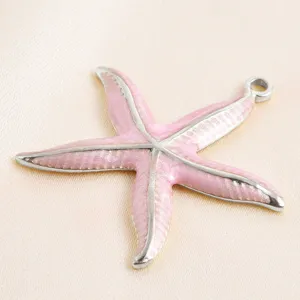 Détail pendentif étoile de mer rose émaillé, gros plan accessoire bijou DIY charmant.