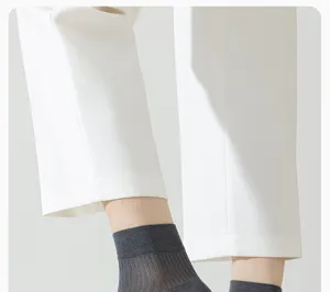 Gros plan de chaussettes mi-mollet respirantes pour hommes en gris foncé avec maille confortable.