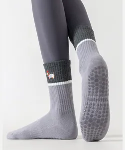 Gray non-slip grip yoga socks detail view showing textured silicone dots and dog embroidery.
