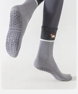 Detailed view of grey non-slip yoga socks featuring cute puppy embroidery and silicone grip dots.