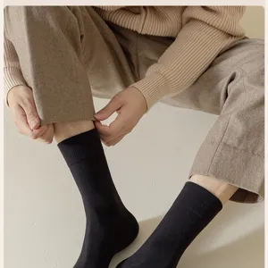 Detailed view of cozy black ribbed crew socks worn by model in winter, soft and warm.