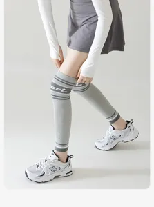 Detail view of grey compression knee sleeves with white stripes and sport text print.
