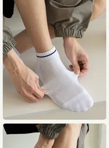 Men's breathable white sports socks detail showing elastic mesh knit fabric and ankle stripe design.
