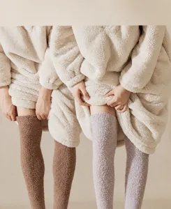 Détail de chaussettes hautes douillettes en polaire corail et ensemble loungewear pour l'hiver.