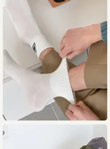 Men's white mid-calf cotton socks with mountain embroidery, showing great stretch for daily wear.