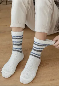 Detail shot of cozy men's coral fleece striped warm sleep socks in soft fluffy plush texture.
