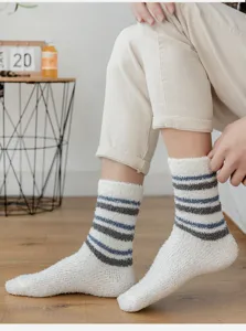 Close-up detail of cozy white coral fleece socks featuring blue and grey stripes for men.