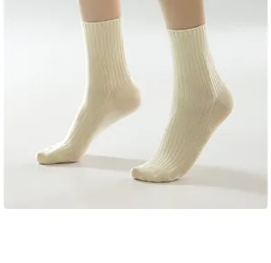 Close-up detail of women's ribbed cotton mid-tube socks in white, comfortable stretch fit.