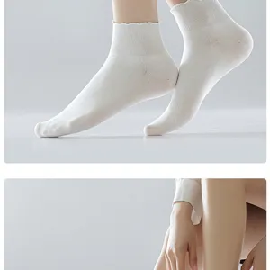 White ruffle edge short socks detail showing delicate lace trim and soft cotton texture.