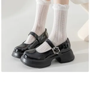 Detail shot of black Mary Jane platform shoes paired with white mesh mid-calf socks.
