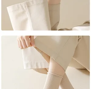 Close-up detail of women's ribbed cotton socks and casual trousers fabric texture in soft beige tone