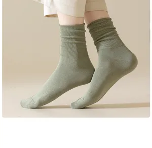 Close-up view of casual green ribbed slouch socks, soft cotton fabric detail showing.