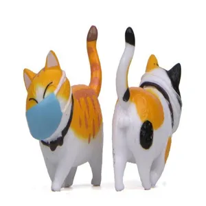 Detailansicht der niedlichen, runden Katzenfigur mit kleiner Gesichtsmaske, kreative Miniaturdeko.