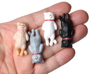 Close up of cute sleeping cat figurine charms set, mini resin toy pendants details view.