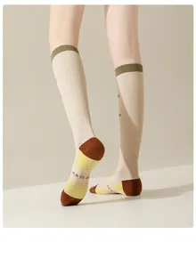 Detailed view of women compression athletic knee-high socks with plaid sole and green cuffs.