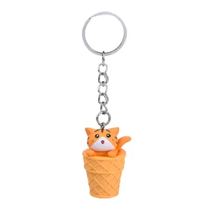 Cute cat in ice cream cone keychain close-up, detailed texture and metal ring pendant.