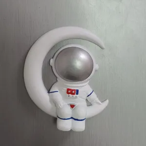 Detailansicht von weißem Astronaut auf Mondsichel Harz Kühlschrankmagnet Dekoration.