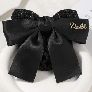 Elegant black bow hair net with satin and tweed texture, perfect for professional work wear.