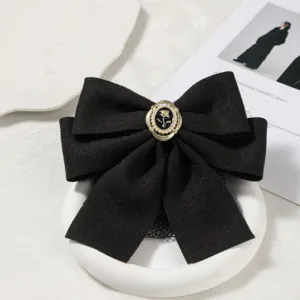 Black retro bow hair clip detail shot, elegant fabric hair accessory with vintage pearl button.