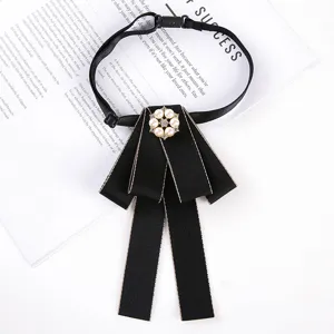 Detailed view of women's black bow tie collar flower with pearl rhinestone center for uniform.
