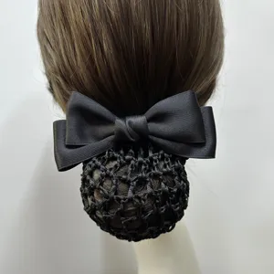 Detail view showing the elegant black satin bow and woven net design of the professional hair bun.
