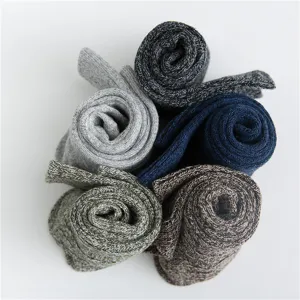 Detail view of men's thick warm wool socks rolled neatly in assorted vintage colors.