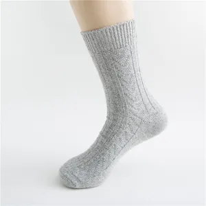 Close-up detail of cozy gray knit wool socks featuring retro textured weave pattern.