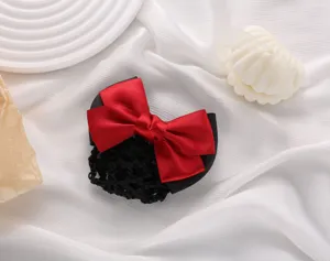 Detailed view of professional red bow hair net bun cover, elegant fabric hair accessory.