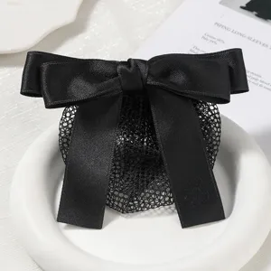 Close-up detail of the elegant black satin bow hair net, showing fine fabric and mesh structure.