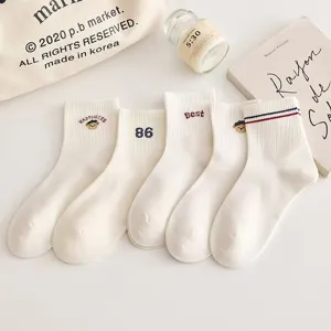 Gros plan de belles chaussettes mi-hautes en coton blanc avec de jolies broderies.