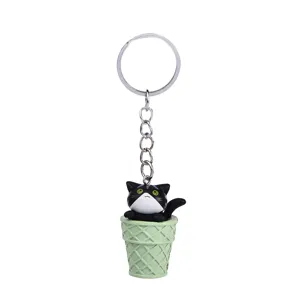 Close-up of a cute black and white cat inside a waffle ice cream cone keychain pendant detail.