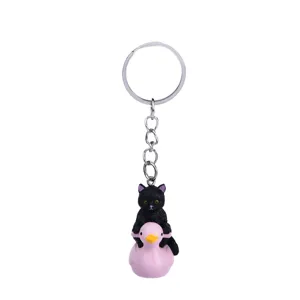 Simpatico gatto nero su anatra rosa portachiavi, accessorio creativo per borsa e auto.