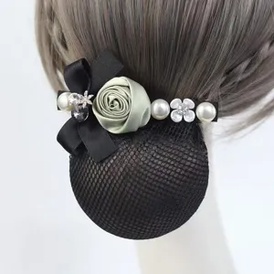 Elegant hair bun net detail showcasing sage rose, pearls, and black bow accessory.