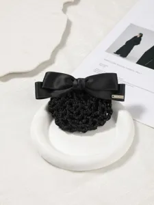 Close-up detail shot of a black satin bow hair net clip, featuring a delicate metal accent.