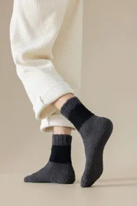 Detaillierte Nahaufnahme von dunkelgrauen flauschigen Korallenfleece-Schlaf-Socken.