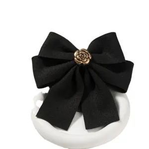 Black retro hair bow clip with gold flower accent, elegant professional bun hair accessory.