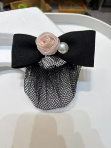 Close-up detail of black bow hair net with pink rose flower and pearl decor for elegant women.