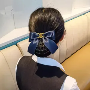Professional hair net bow detail close-up, elegant blue satin bun cover for work and service.