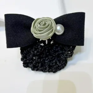 Detailed close-up of elegant black hair net bow with sage green satin rose and pearl detail.