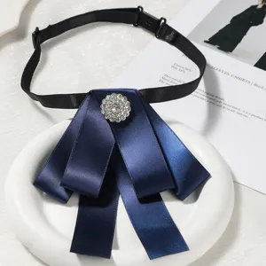 Élégante cravate nœud en satin bleu foncé pour femme avec broche perle strass et sangle noire.