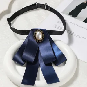 Noeud papillon ruban bleu fonce avec broche perle et sangle reglable pour femmes.